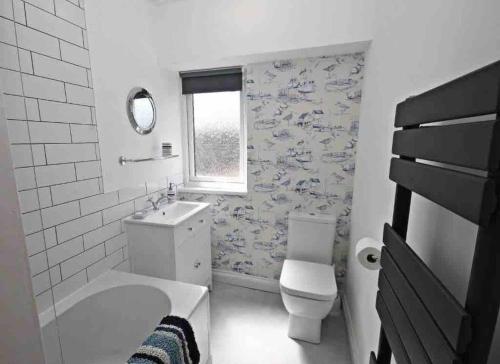 a bathroom with a toilet and a tub and a sink at Charming 2-Bed Cottage in the heart of Stanhope in Bishop Auckland