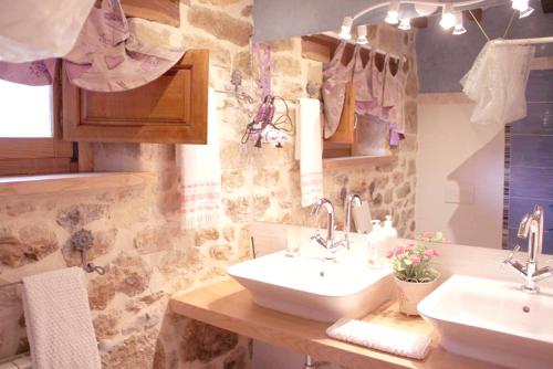 a bathroom with two sinks and a stone wall at Charming House in La Cavada with Jacuzzi in La Cavada