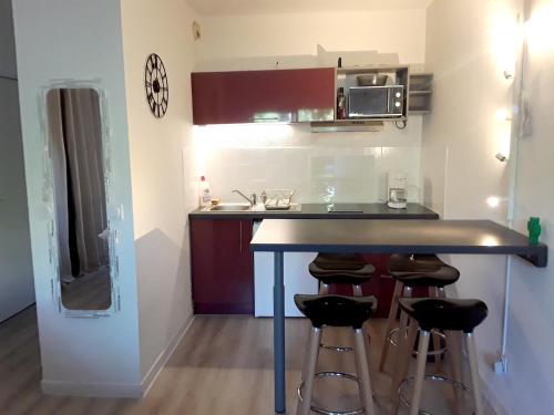 een kleine keuken met een aanrecht en krukken bij Charmant appartement à Cavalaire-sur-Mer avec terrasse in Cavalaire-sur-Mer