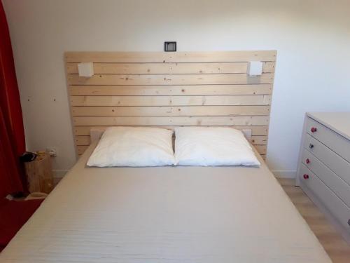 een bed met een houten hoofdeinde in een slaapkamer bij Charmant appartement à Cavalaire-sur-Mer avec terrasse in Cavalaire-sur-Mer
