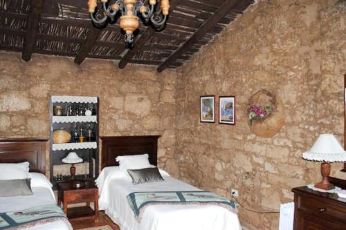 a bedroom with two beds and a stone wall at Cosy House in La Sabinita with Mountain View in La Sabinita
