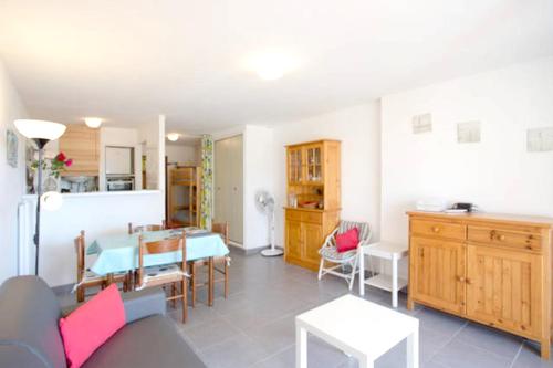 a living room with a table and a dining room at Studio a Bormes les Mimosas a 400 m de la plage avec jardin clos et wifi in Bormes-les-Mimosas