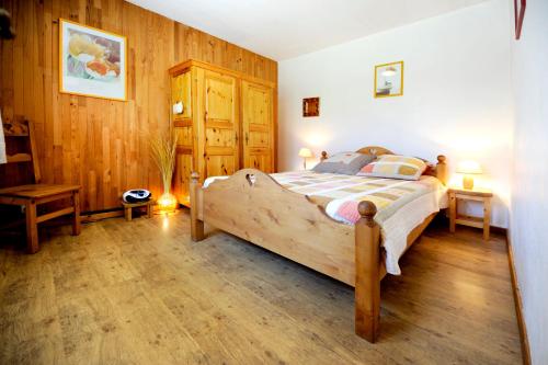 ein Schlafzimmer mit einem Bett und einer Holzwand in der Unterkunft Appartement cosy aux Ménuires 35 m² avec vue montagne in Levassaix