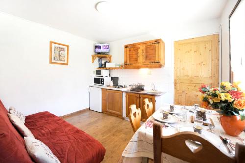 ein Wohnzimmer mit Tisch und Küche in der Unterkunft Appartement cosy aux Ménuires 35 m² avec vue montagne in Levassaix