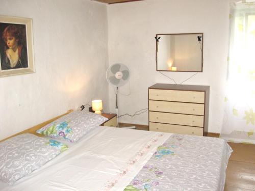 a bedroom with a bed and a dresser and a mirror at Charming House in Sveti Jakov, Mountain View in Sveti Jakov