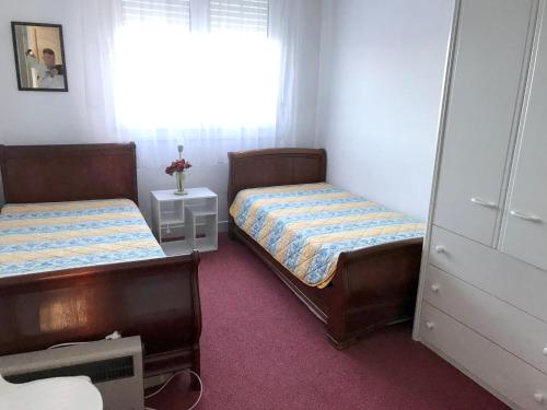 une chambre avec deux lits et une fenêtre dans l'établissement Appartement confortable avec vue sur la mer - Neufchâtel-Hardelot, à Neufchâtel-Hardelot