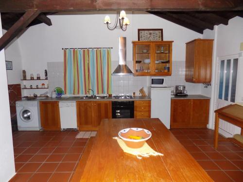 a kitchen with a wooden table with a bowl on it at 3 bedrooms house with shared pool enclosed garden and wifi at Pataias in Pataias