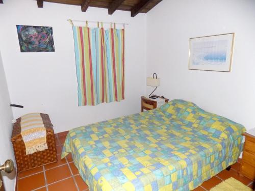 a bedroom with a bed and a chair in it at 3 bedrooms house with shared pool enclosed garden and wifi at Pataias in Pataias