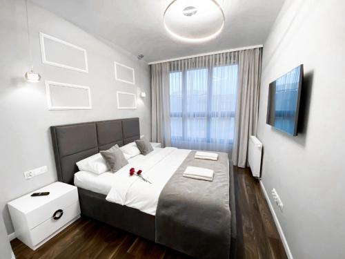 sypialnia z dużym łóżkiem i oknem w obiekcie GA Luxury Apartments W21 w Krakowie