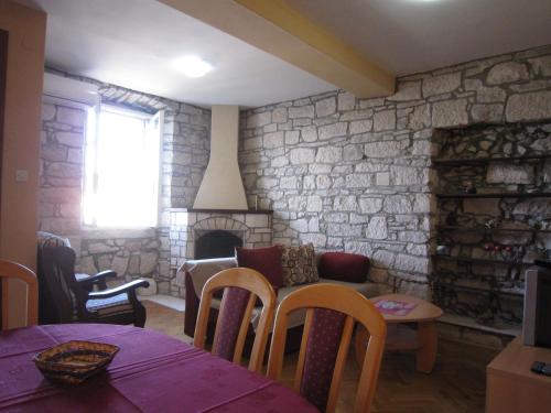 sala de estar con sofá y pared de piedra en Apartment Ivan, en Račišće