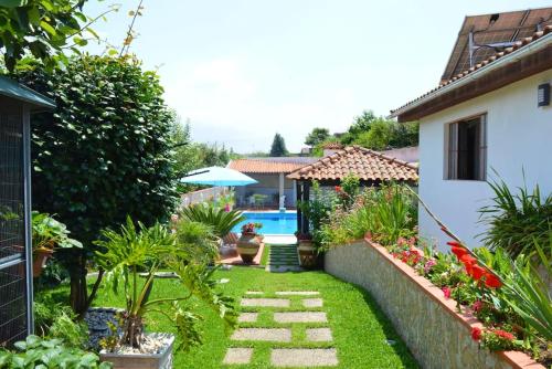 een achtertuin met een zwembad en een tuin bij 3 bedrooms villa with private pool furnished terrace and wifi at Oliveira de Azemeis in Oliveira de Azemeis