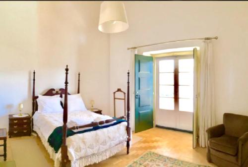 a bedroom with a bed and a chair and a door at 2 bedrooms appartement at Praia do Ribatejo 200 m away from the beach with lake view enclosed garden and wifi in Praia do Ribatejo
