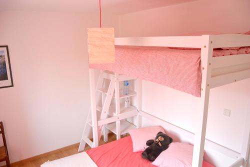 un osito de peluche sentado en una cama en una litera en Maison de 2 chambres avec jardin clos et wifi a Saint Jouan des Guerets a 1 km de la plage, en Saint-Jouan-des-Guérets