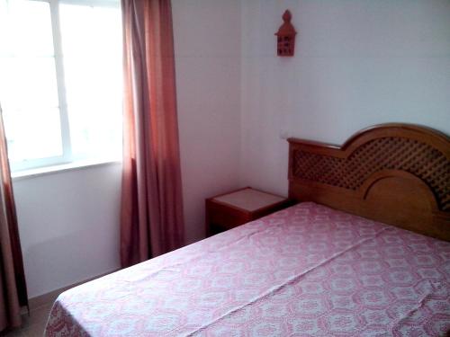 a bedroom with a bed and a window at One bedroom apartement with city view shared pool and enclosed garden at Albufeira 2 km away from the beach in Albufeira