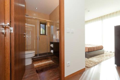 a bathroom with a toilet and a glass shower door at Elegant Villa Near Vieira do Minho with Pool in Vieira do Minho