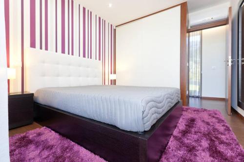 a bedroom with a bed and a purple rug at Elegant Villa Near Vieira do Minho with Pool in Vieira do Minho