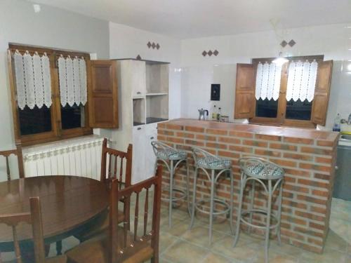 uma cozinha com um balcão de tijolos e uma mesa e cadeiras em 3 bedrooms house with garden at Isongo em Isongo
