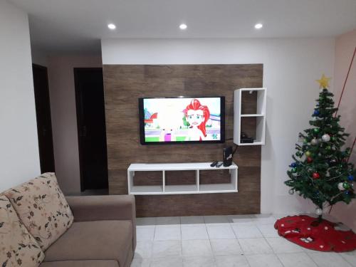 a living room with a christmas tree and a television at Casa na praia dos ingleses in Florianópolis