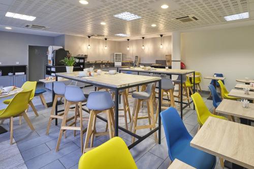 a restaurant with tables and chairs in a cafeteria at Comfort Aparthotel Carcassonne in Carcassonne