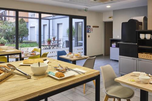 a kitchen with a table and chairs in a room at Comfort Aparthotel Carcassonne in Carcassonne