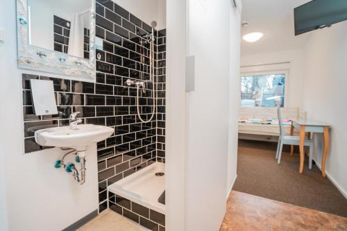 a bathroom with a sink and a bedroom at Motel Home Berlin in Berlin