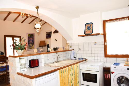 une cuisine avec un évier et un lave-vaisselle dans l'établissement Appartement chaleureux avec piscine à La Roche-sur-le-Buis - 90 m², à La Roche-sur-le-Buis