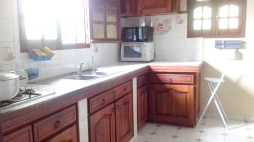 a kitchen with a sink and a microwave at Appartement panoramique Bouillante in Bouillante