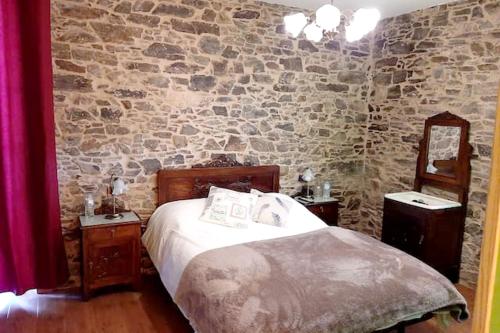 1 dormitorio con cama y pared de piedra en 4 bedrooms villa with private pool enclosed garden and wifi at Empalme de Vilar en Vilar