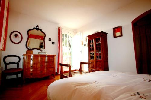 een slaapkamer met een bed, een dressoir en een spiegel bij Villa de 4 chambres avec vue sur la mer piscine privee et jardin amenage a Hyeres a 2 km de la plage in Hyères