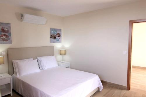 a white bedroom with a white bed and a window at Elegant House in Calheta, Sea View in Calheta
