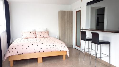 a bedroom with a bed and two black chairs at Studio avec wifi a Argenteuil in Argenteuil