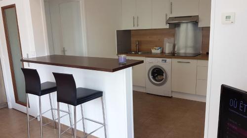 a kitchen with a counter and two bar stools at Studio avec wifi a Argenteuil in Argenteuil