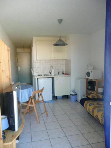 Cette chambre comprend une cuisine avec une table. dans l'établissement Appartement cosy avec vue sur la mer à Sainte-Marie - 30 m², à Sainte-Marie-la-Mer