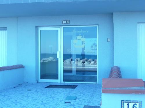 un accès à un bâtiment avec une porte en verre dans l'établissement Appartement cosy avec vue sur la mer à Sainte-Marie - 30 m², à Sainte-Marie-la-Mer