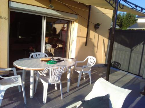 een witte tafel en stoelen op een patio bij Appartement de 2 chambres avec vue sur le lac jardin clos et wifi a Salles Curan in Salles-Curan