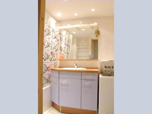 une salle de bain blanche avec un lavabo et un miroir dans l'établissement Appartement charmant Châtel 70 m² + Terrasse, à Châtel