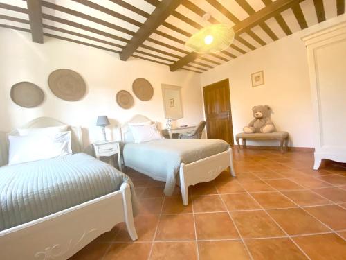 a bedroom with two beds and a teddy bear on a chair at Villa élégante à Murs avec piscine privée in Murs