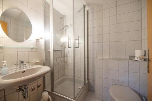 a bathroom with a shower and a sink and a toilet at Pension & Café Abendröte in Kurort Oybin