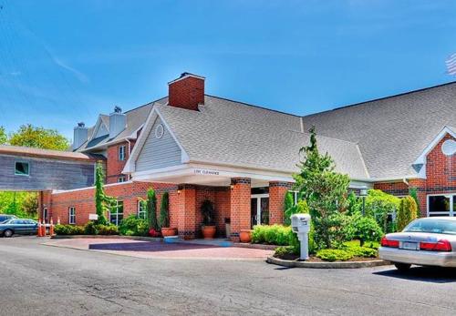 a house with a car parked in front of it at Hawthorn Suites by Wyndham Erie in Erie