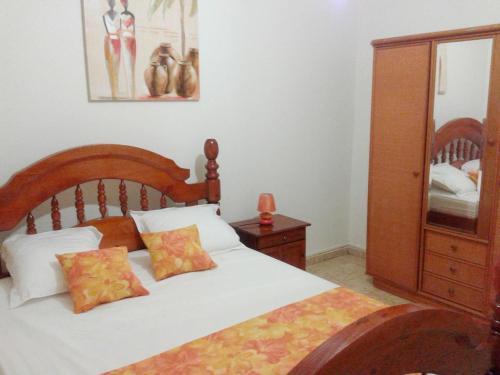 a bedroom with a bed and a dresser and a mirror at Appartement confortable Pointe-Noire + Terrasse in Pointe-Noire