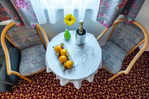 a table with a plate of fruit and a vase at Pension & Café Abendröte in Kurort Oybin