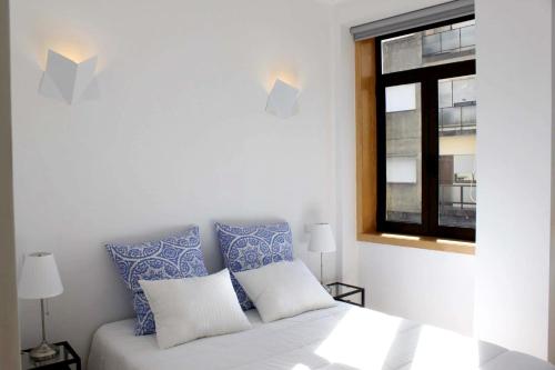 a bedroom with a bed with blue and white pillows at Spacious House in Porto + Garden in Porto
