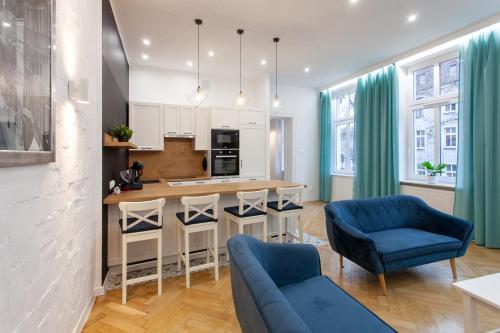 una cocina con sillas azules y una isla de cocina en Victoria Apartment, en Gliwice