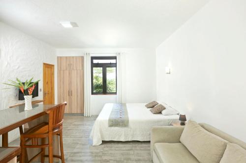 a white room with a bed and a couch at Studio with city view furnished terrace and wifi at Moka in Moka
