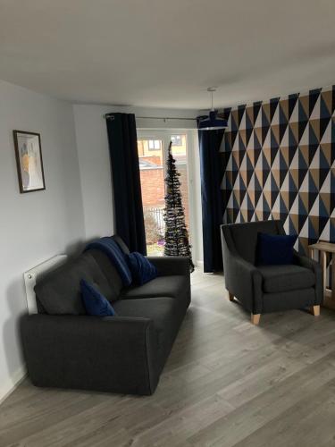 a living room with a couch and a christmas tree at Chapel Court Apartments in Cannock