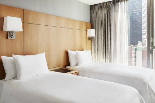 two beds in a hotel room with a window at Club Quarters Hotel World Trade Center, New York in New York