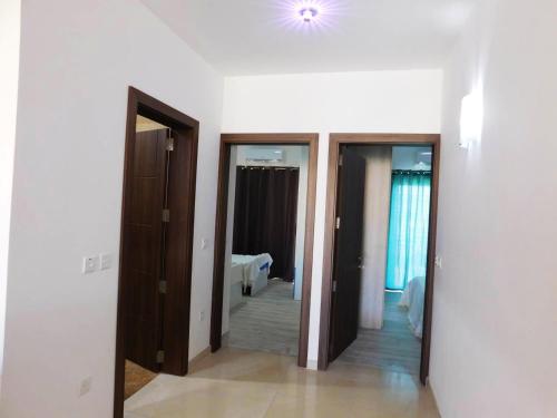 a hallway with three doors and a room with a bed at Bright apartment with sea view in Għajnsielem - 120 sqm in Għajnsielem