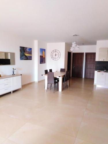 a dining room and kitchen with a table and chairs at Bright apartment with sea view in Għajnsielem - 120 sqm in Għajnsielem