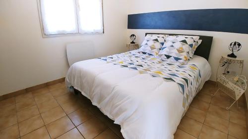 een slaapkamer met een groot wit bed met een blauw hoofdeinde bij Caroline in Oyonnax