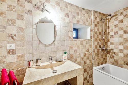 a bathroom with a sink and a tub and a mirror at Charmante Maison à Bonnieux avec Terrasse et Vue sur le Jardin in Bonnieux